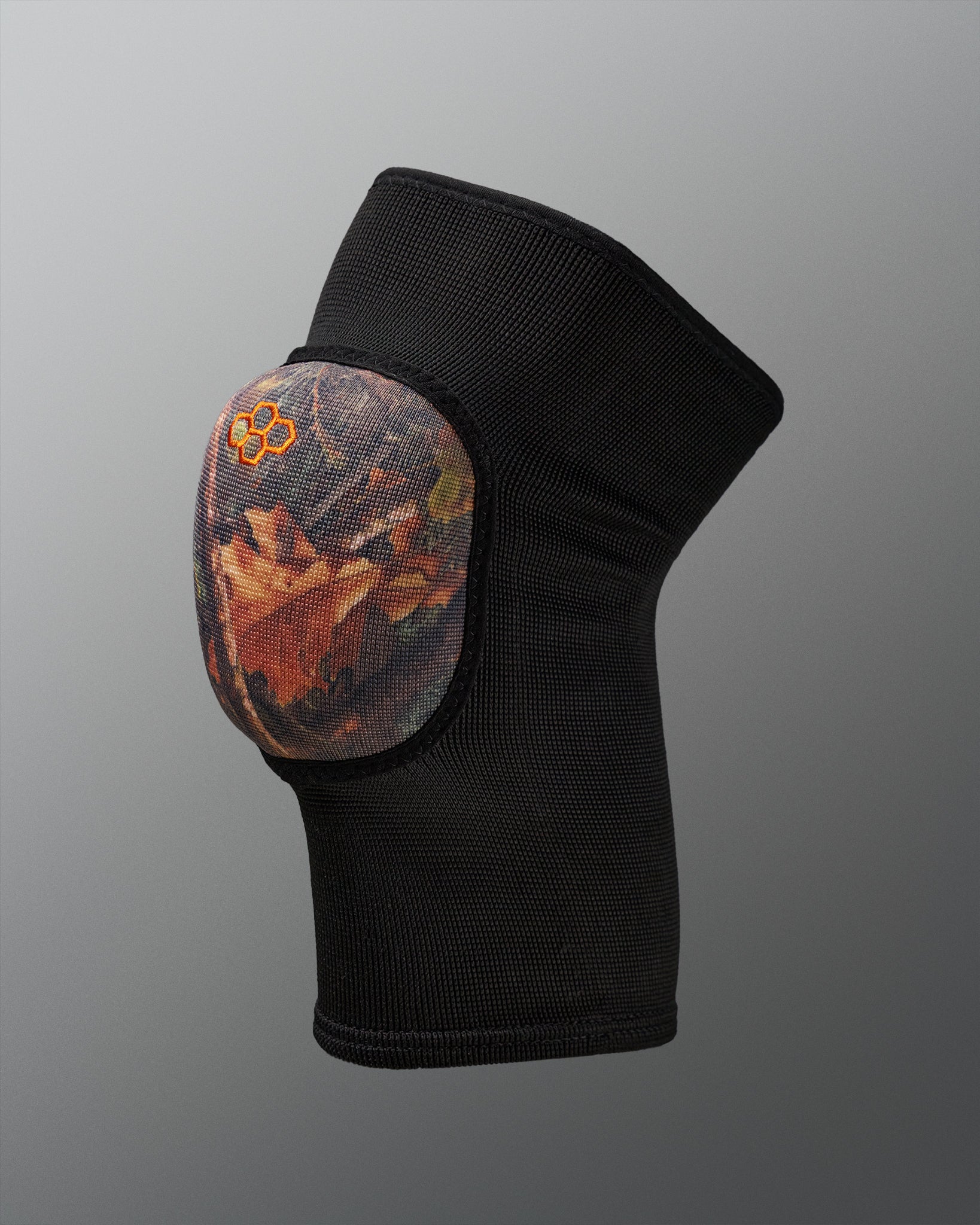 Black knee pad with a camo design on a gray background