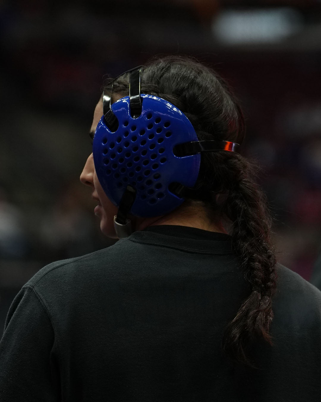 Person wearing a blue headgear with a dark background