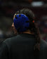 Person wearing a blue headgear with a dark background
