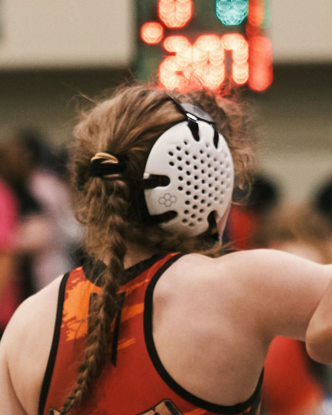 Person wearing a wrestling headgear and tank top with a blurred background
