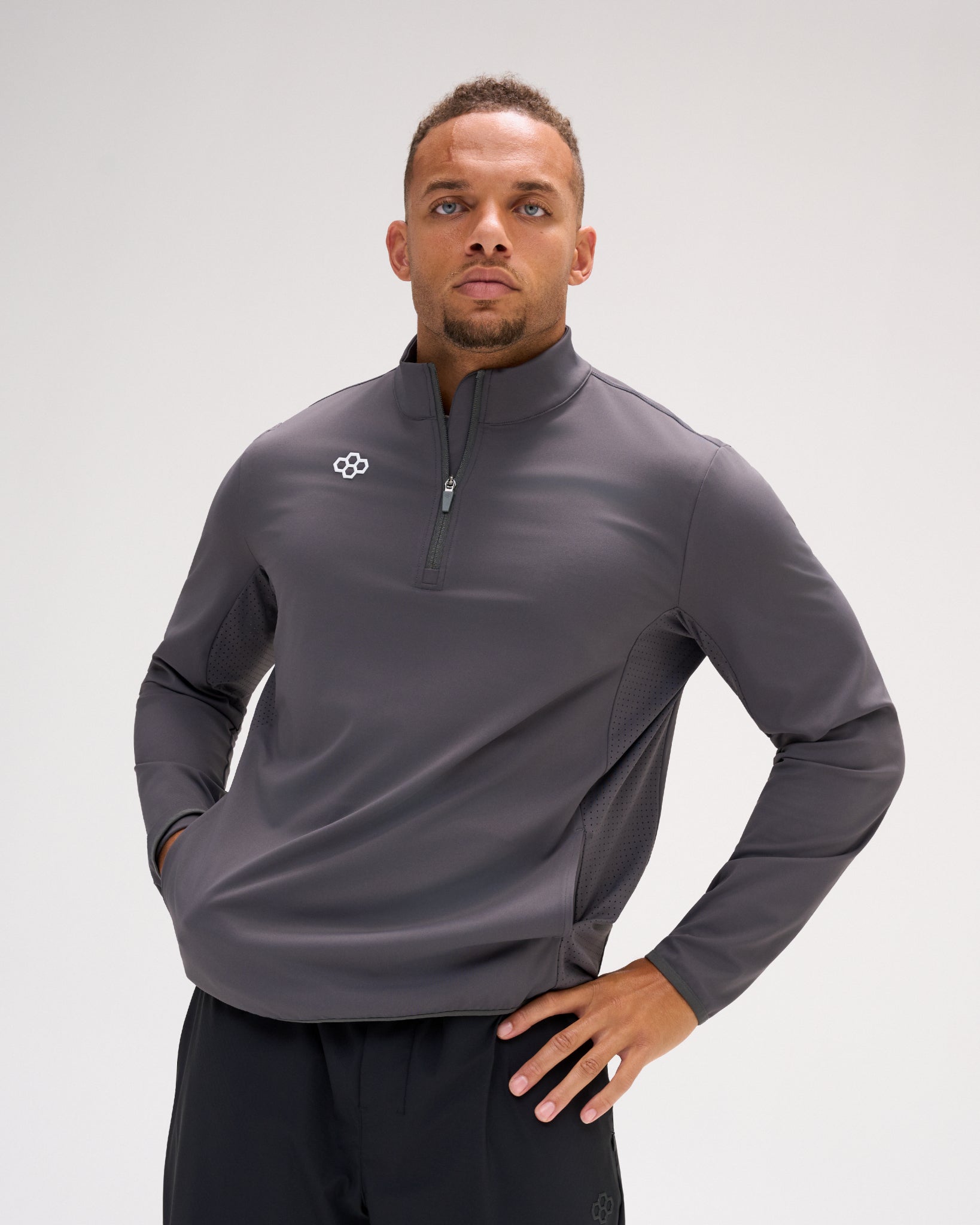 Man wearing the carbon RUDIS Victory 1/4 Zip performance pullover with RUDIS chest logo, quarter-zip collar and ventilated side panels.