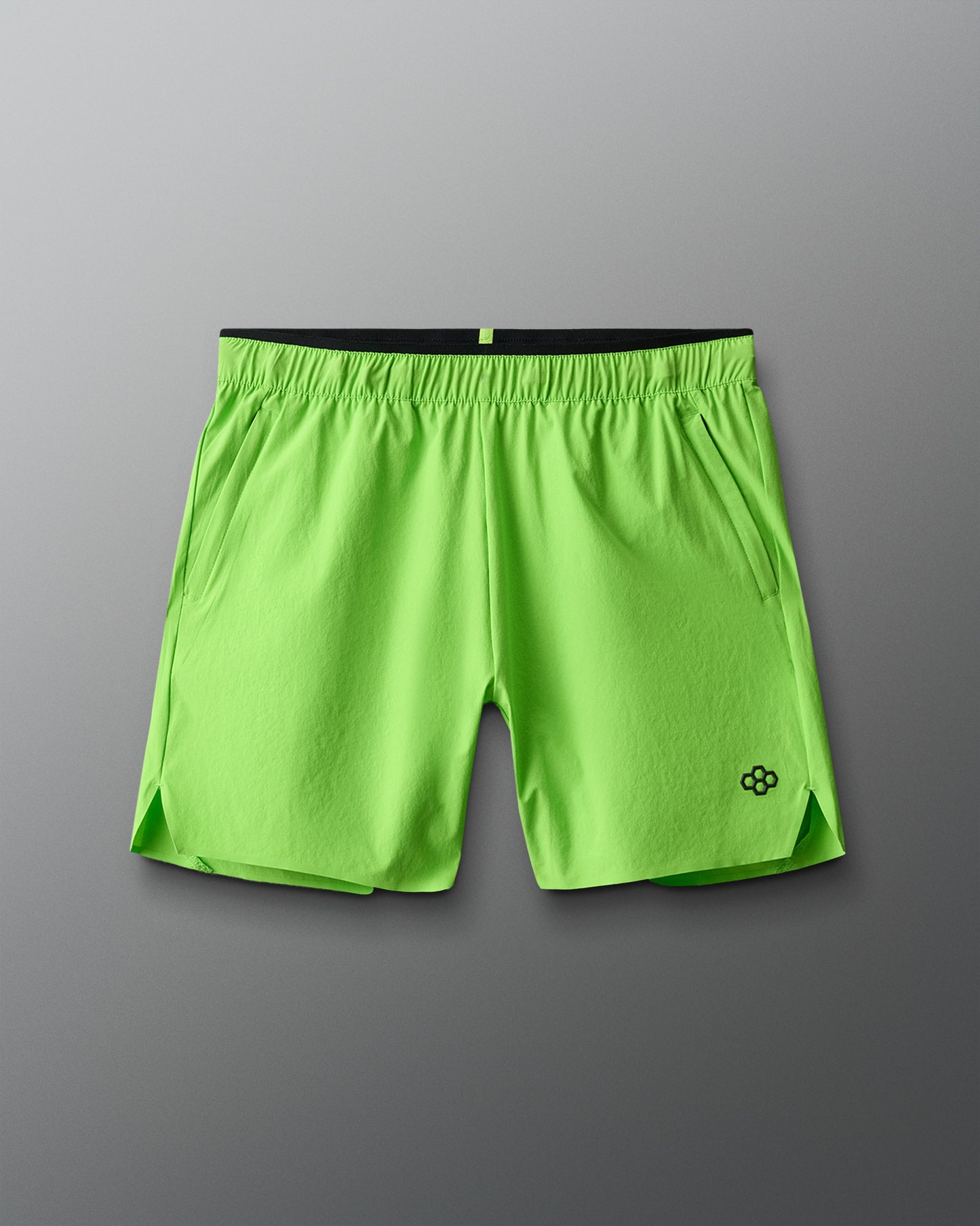 Green athletic shorts with a brand logo on a gray background