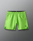 Green athletic shorts with a brand logo on a gray background