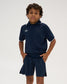 Front view of a youth model wearing the RUDIS Chronicle Elite Youth Athletic Polo in Navy, featuring a short-sleeve design, white-trimmed collar and cuffs, and white RUDIS chest logo.