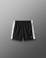 Black shorts with white side panels on a gray background