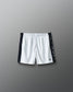 White shorts with black side panels on a gray background