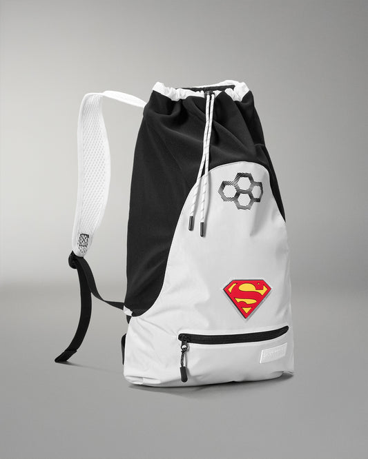 Angled front view of the RUDIS Superman Double Cinch wrestling backpack in black and white with Superman shield logo and front zip pocket.