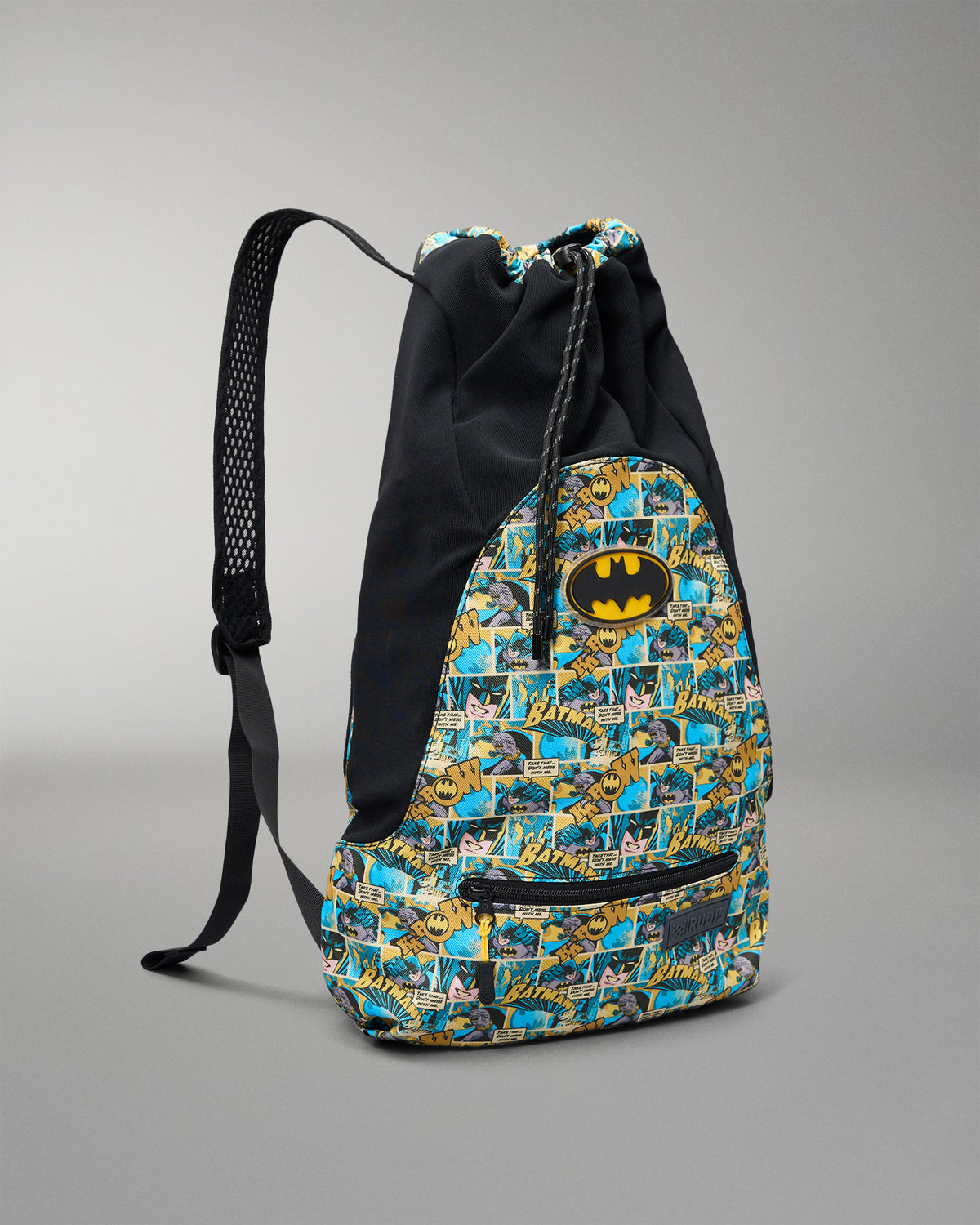 Angled front view of the RUDIS Batman Double Cinch wrestling backpack with black panels, Batman comic print, drawstring closure, and front zip pocket.