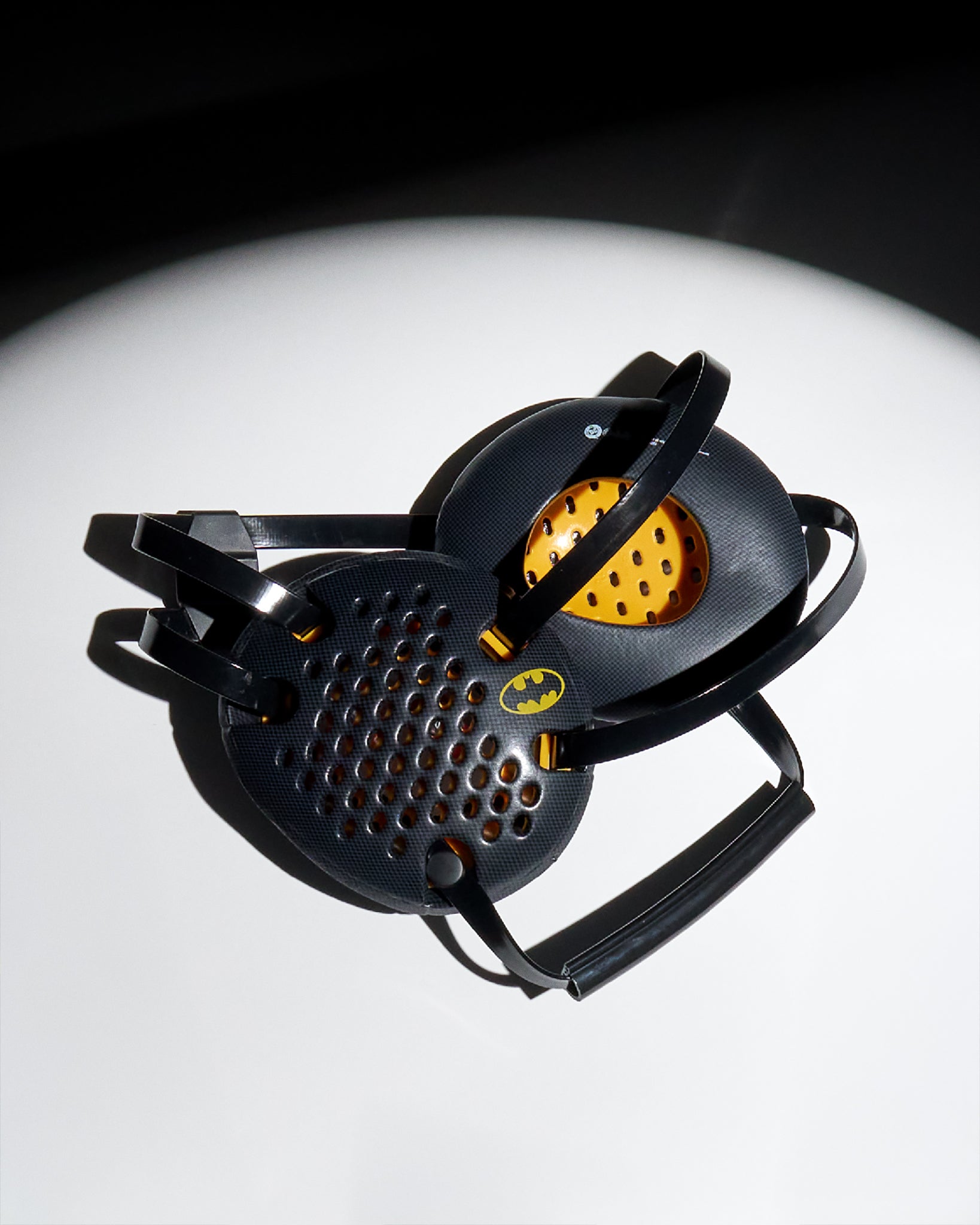 RUDIS Batman Elite Airflow wrestling headgear in black and yellow featuring ventilated ear guards, adjustable straps, and the classic Batman logo.
