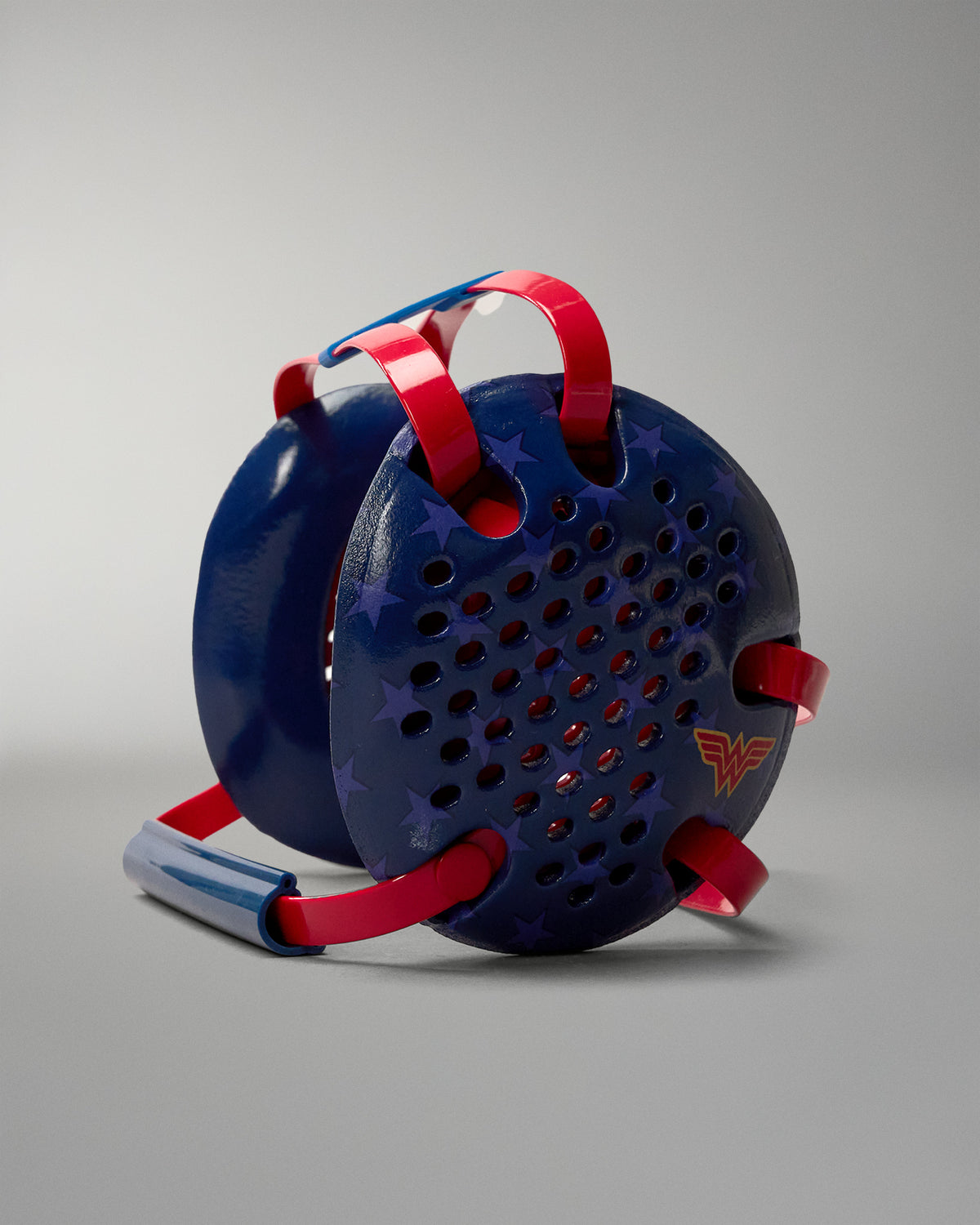 Opposite side view of RUDIS Wonder Woman Elite Airflow Wrestling Headgear with navy blue ventilated ear guards, red straps and gold Wonder Woman emblem.