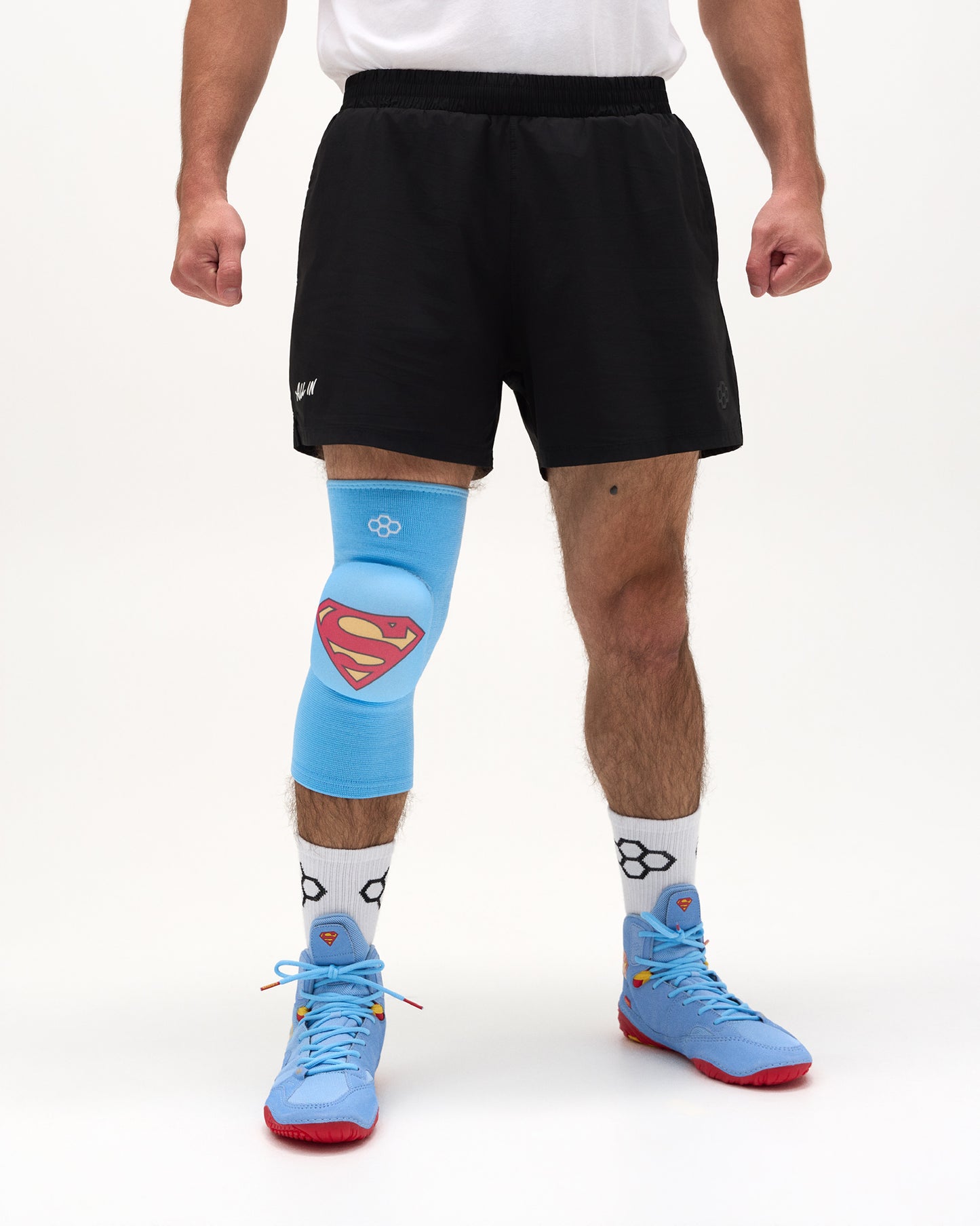 Front view of wrestler wearing the blue RUDIS Superman Cushion Kneepad with padded Superman shield over the knee.