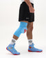 Side view of blue RUDIS Superman Cushion Kneepad worn during training with matching Superman wrestling shoes.
