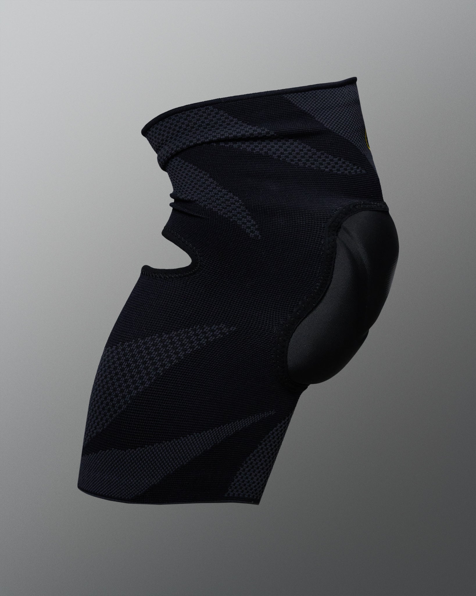 Rear angled view of the RUDIS Batman Elite Cushion wrestling knee pad showing the black compression sleeve and contoured knee padding.