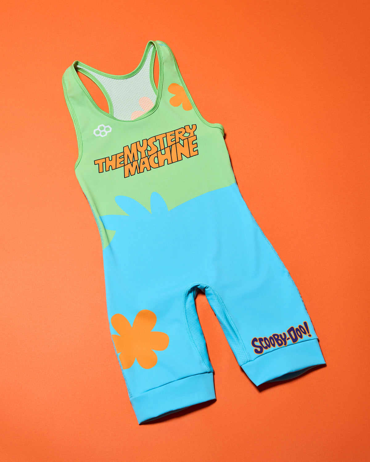 RUDIS Scooby-Doo Mystery Machine Elite 2.0 wrestling singlet laid flat on an orange background, featuring lime green and turquoise panels, orange flower graphics, Mystery Machine lettering, and Scooby-Doo logo.