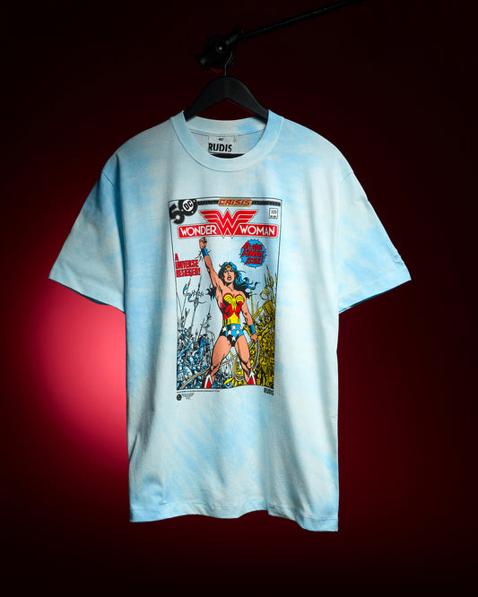 RUDIS Wonder Woman Comic Relaxed Cotton T-Shirt in blue tie dye, hanging against a red background with a colorful vintage Wonder Woman comic cover graphic.