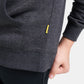A close-up view of a gray hoodie pocket and sleeve featuring a small brand tag in yellow indicative of casual wear