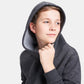 A young boy wearing a gray hoodie with a cozy interior looking thoughtfully to the side with a gentle smile