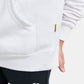 A close-up of a white hoodie featuring a kangaroo pocket and a branded label complemented by black leggings