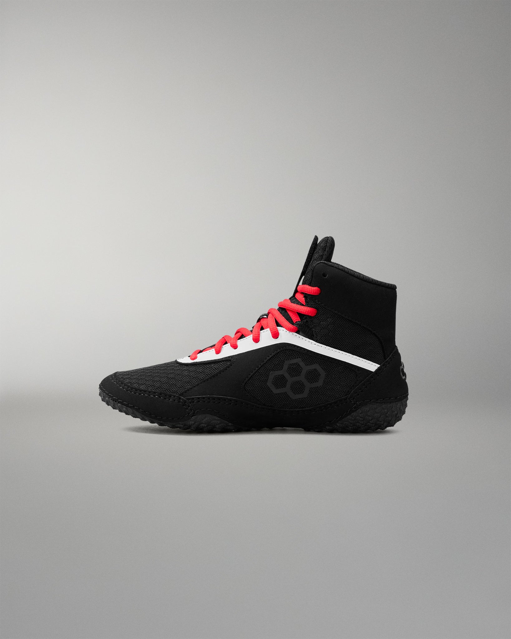 Black wrestling shoe with red laces on a gray background