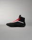 Black wrestling shoe with red laces on a gray background