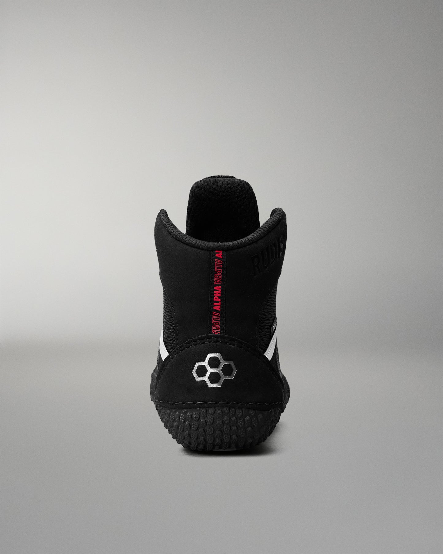 Black wrestling shoe with a brand logo on a gray background