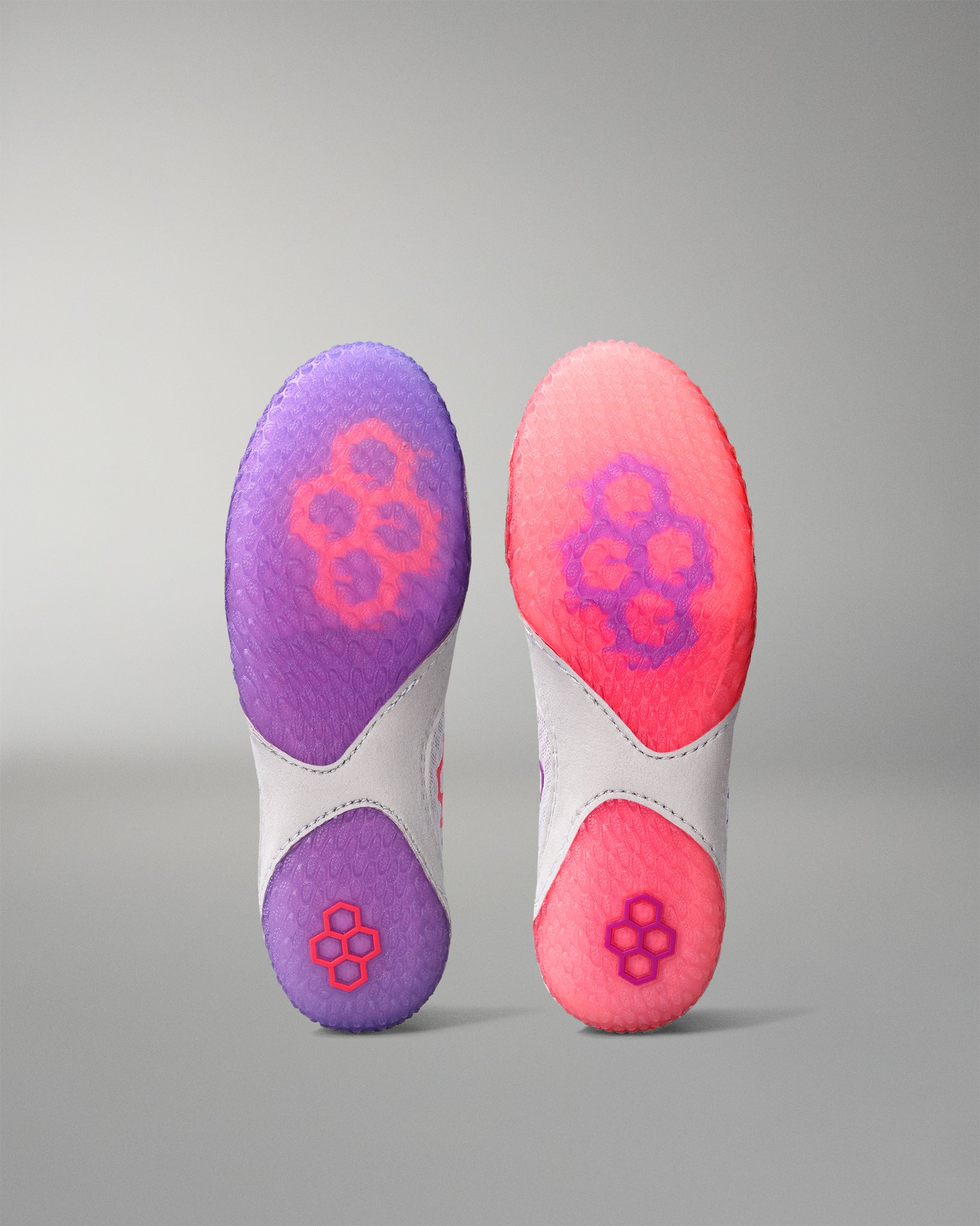 Pair of purple and pink insoles on a gray background