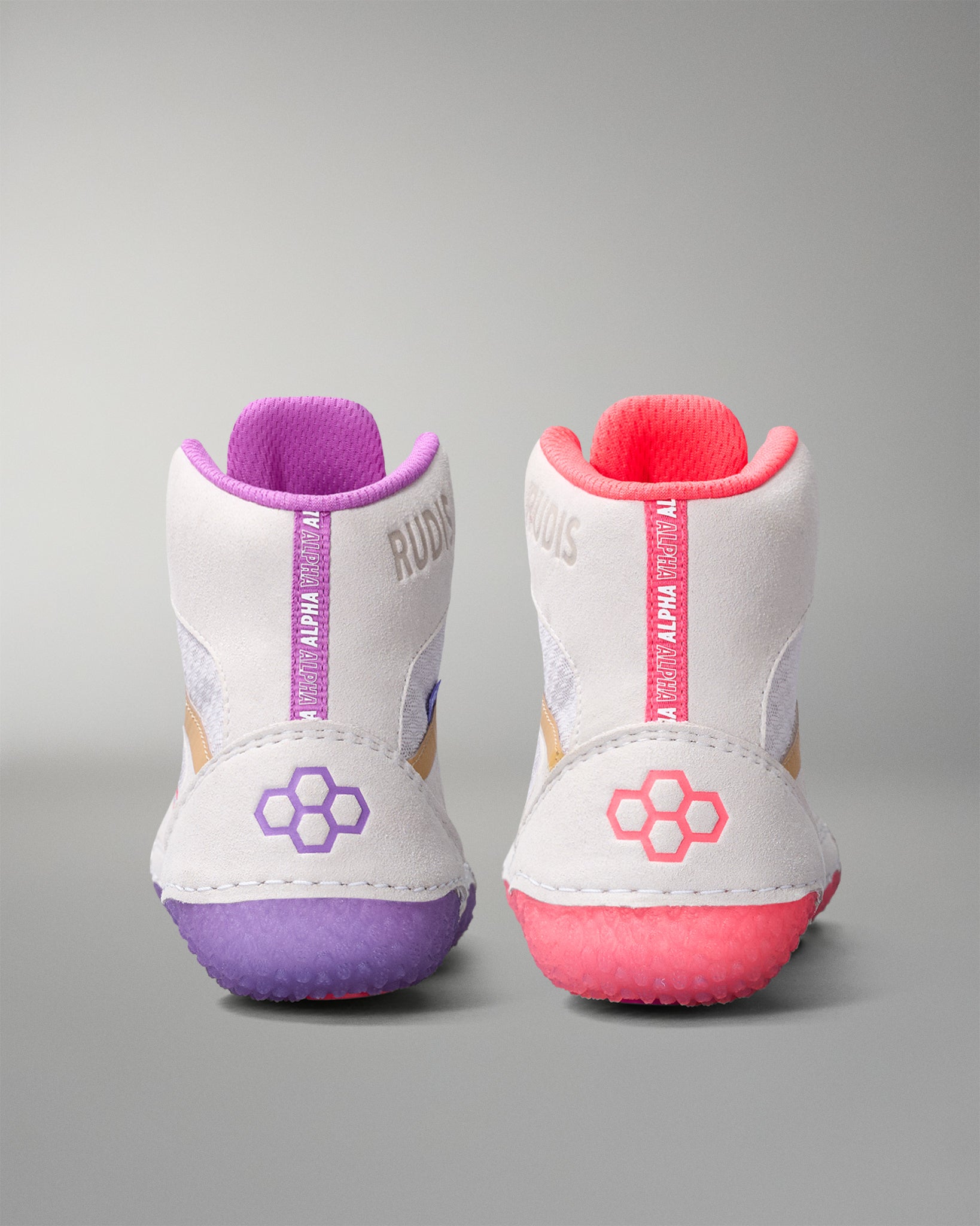 White wrestling shoes with purple and pink soles on a gray background