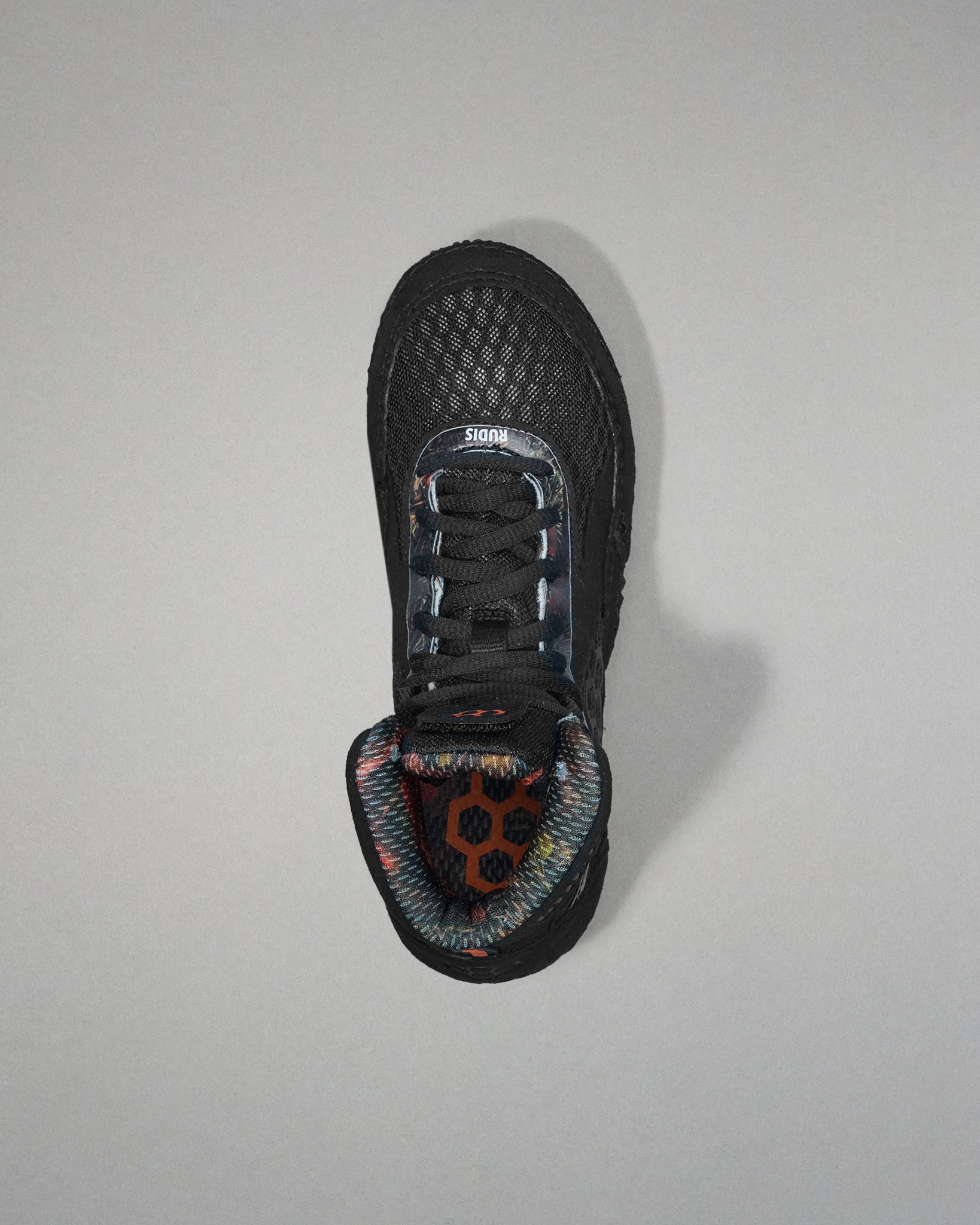 Black wrestling shoe with a unique sole design on a gray background