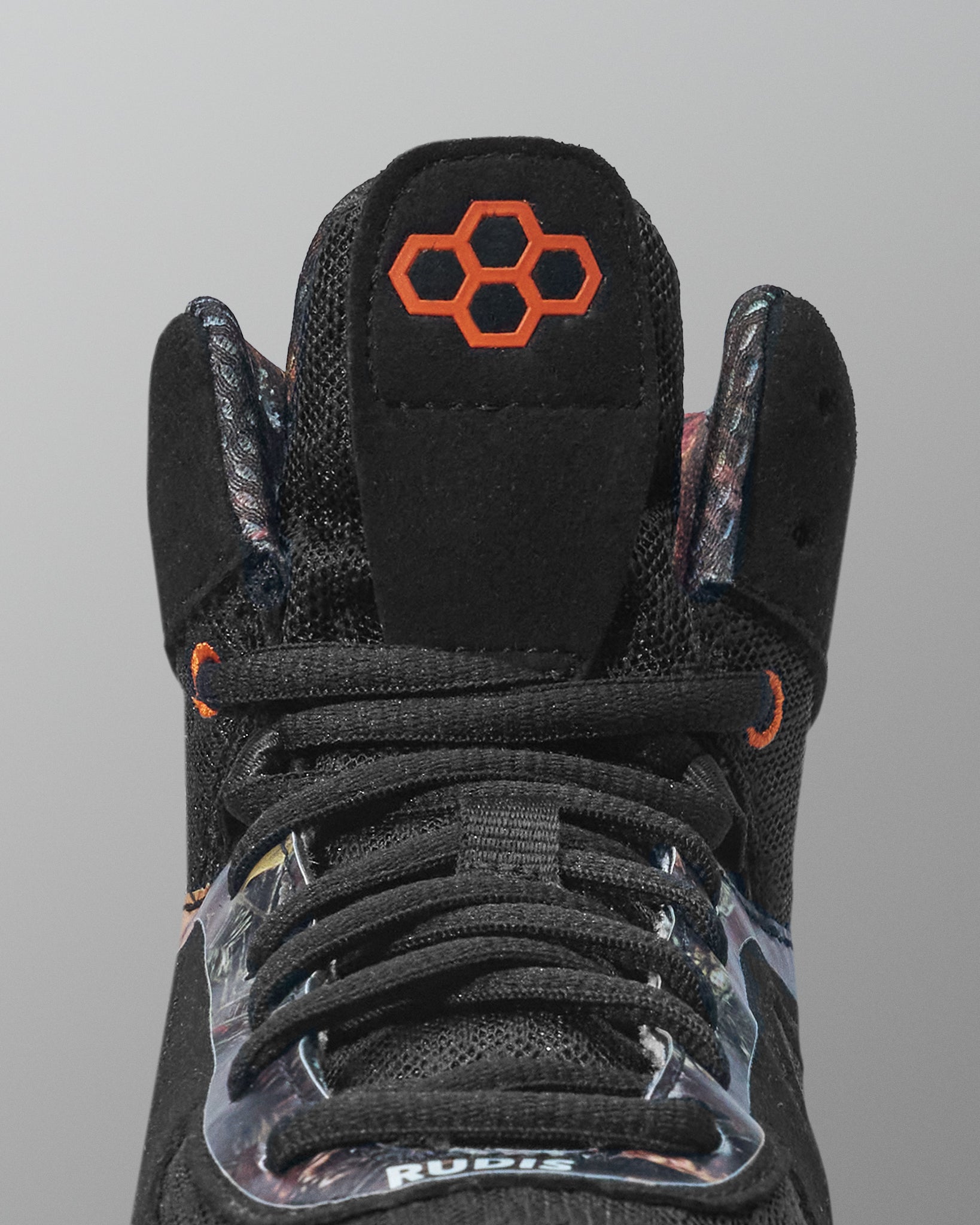 Black wrestling shoe with orange logo on a gray background