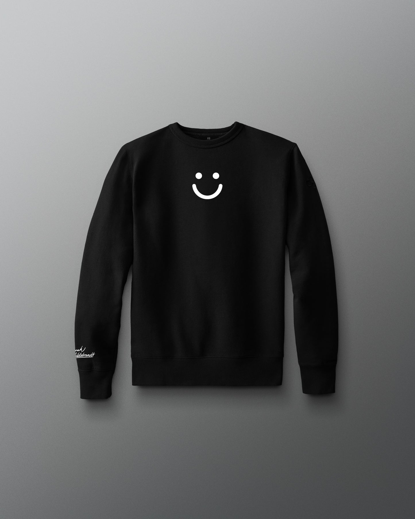 Black long-sleeve shirt with a white smiley face design on a gray background