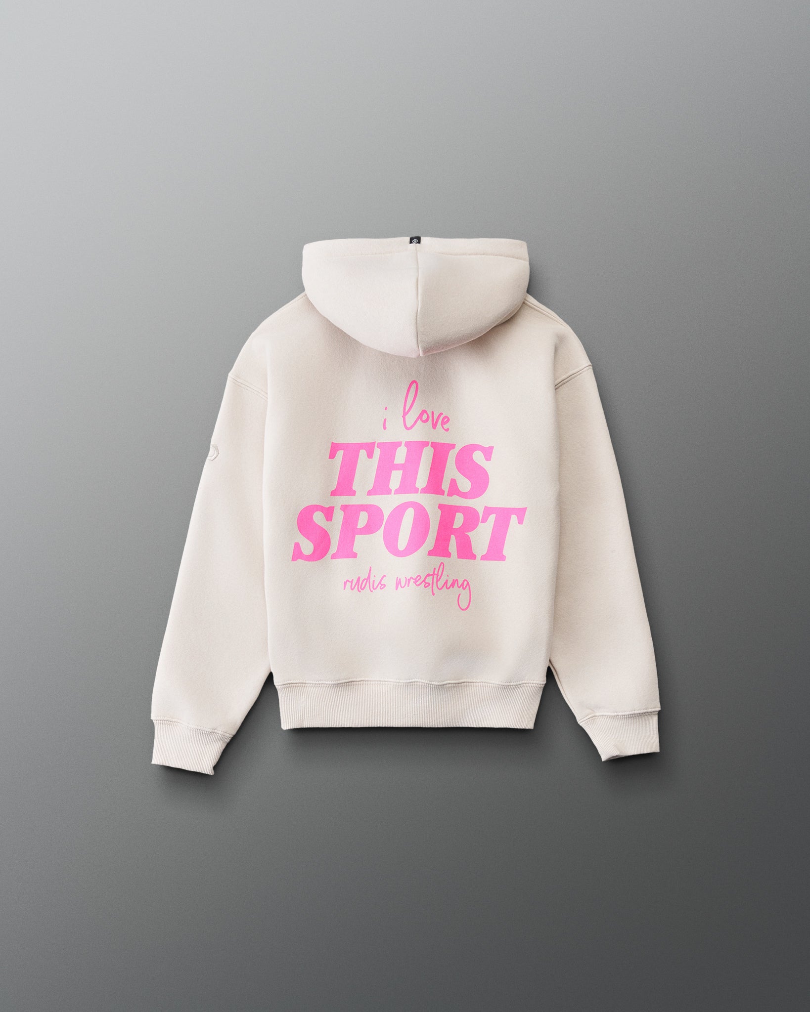 RUDIS Love This Sport Youth Relaxed Comfort Fleece Hoodie in Bone, front view featuring a bright pink chest graphic, matching sleeve accents, kangaroo pocket, and ribbed cuffs and hem.