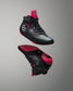 Black and pink wrestling shoes on a gray background