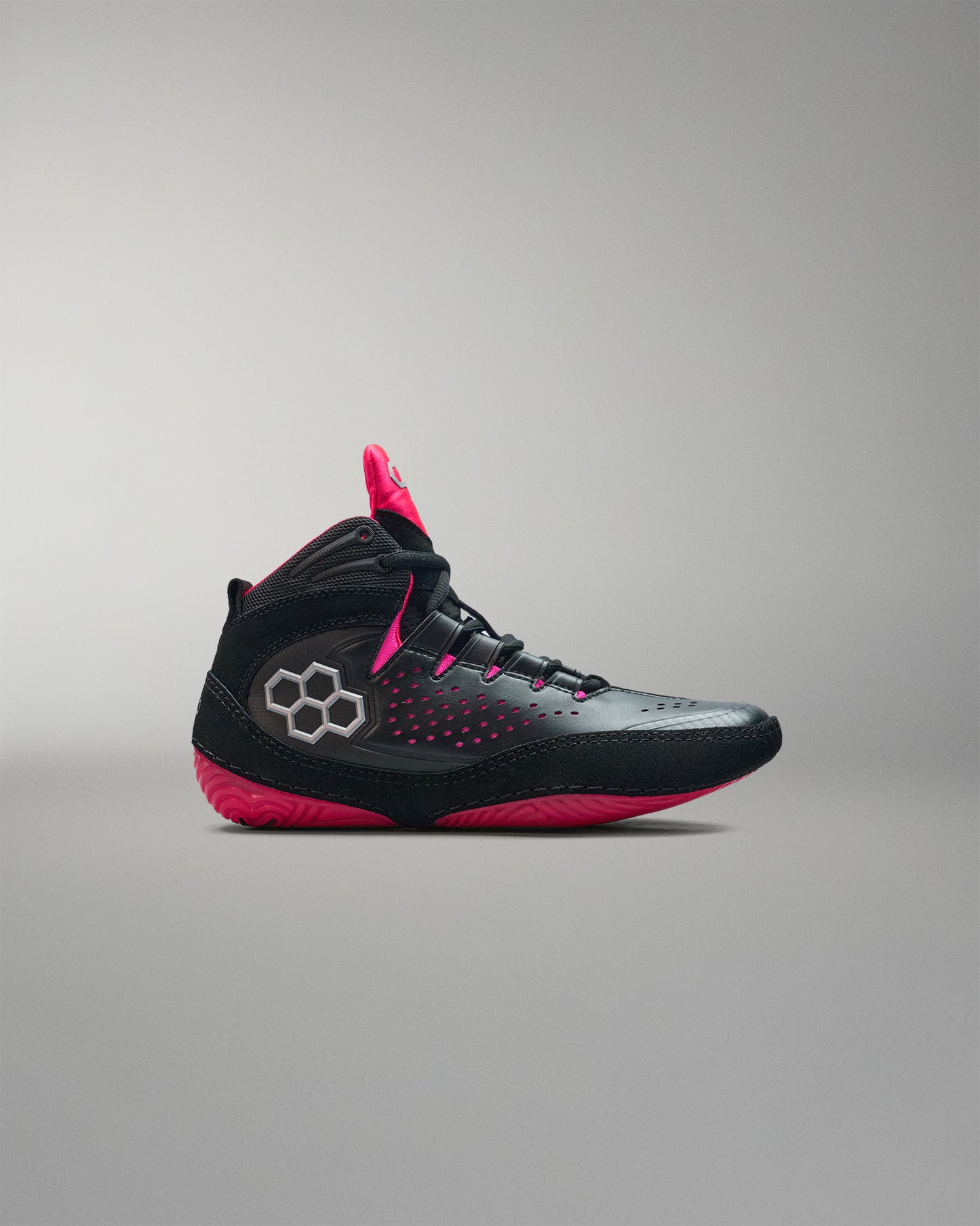 Black and pink wrestling shoe on a gray background