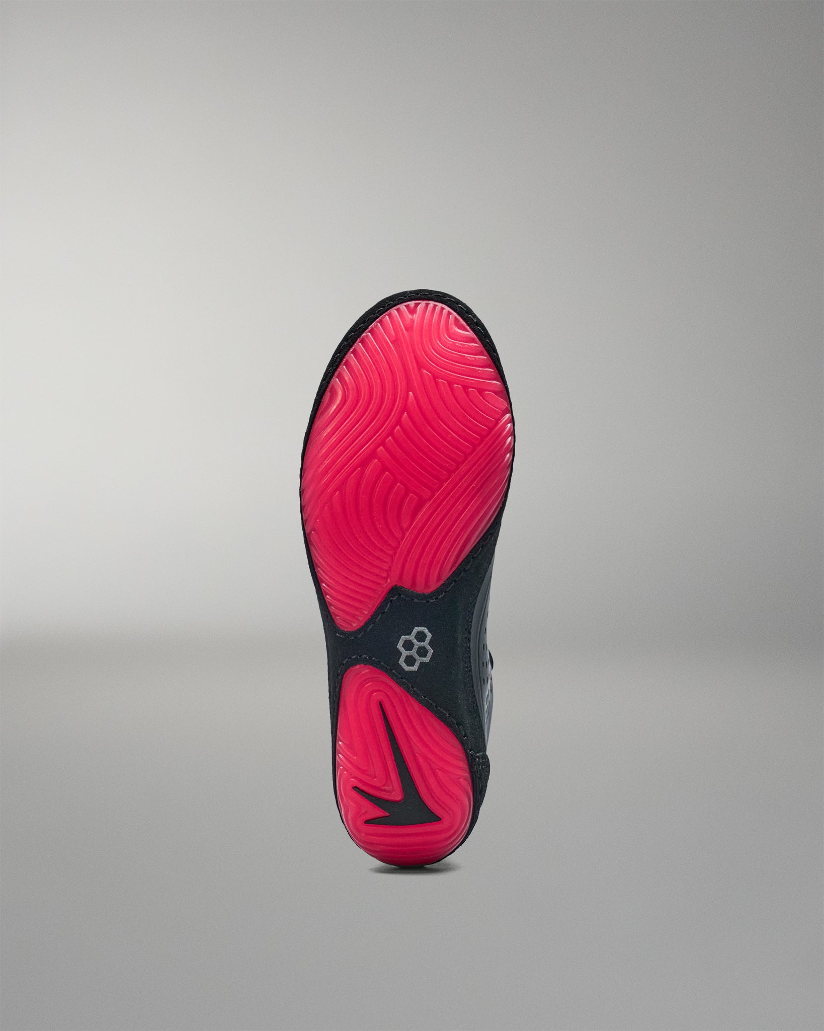 Black and pink sole of a wrestling shoe on a gray background