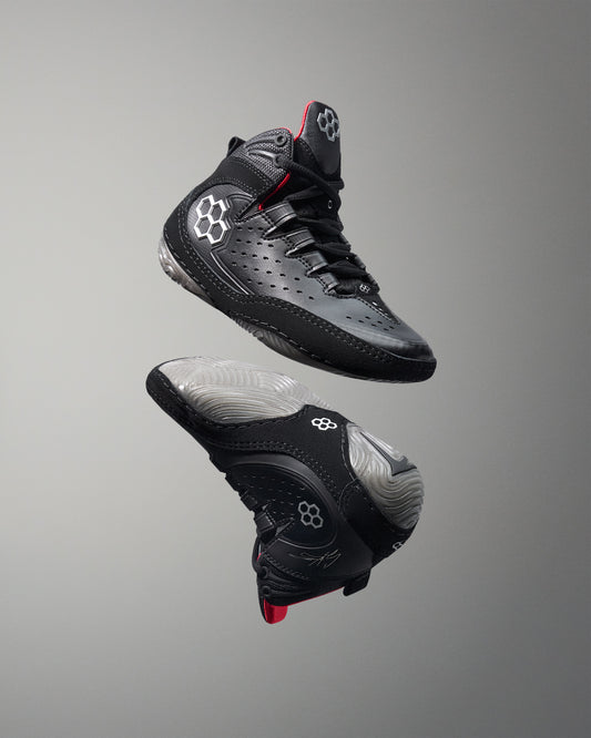 Black wrestling shoes with gray soles on a gray background