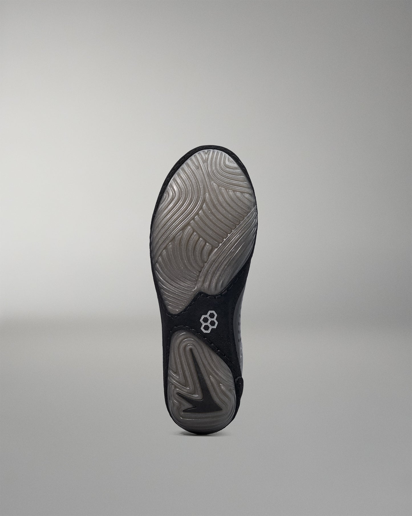Black wrestling shoe sole with a brand logo on a gray background