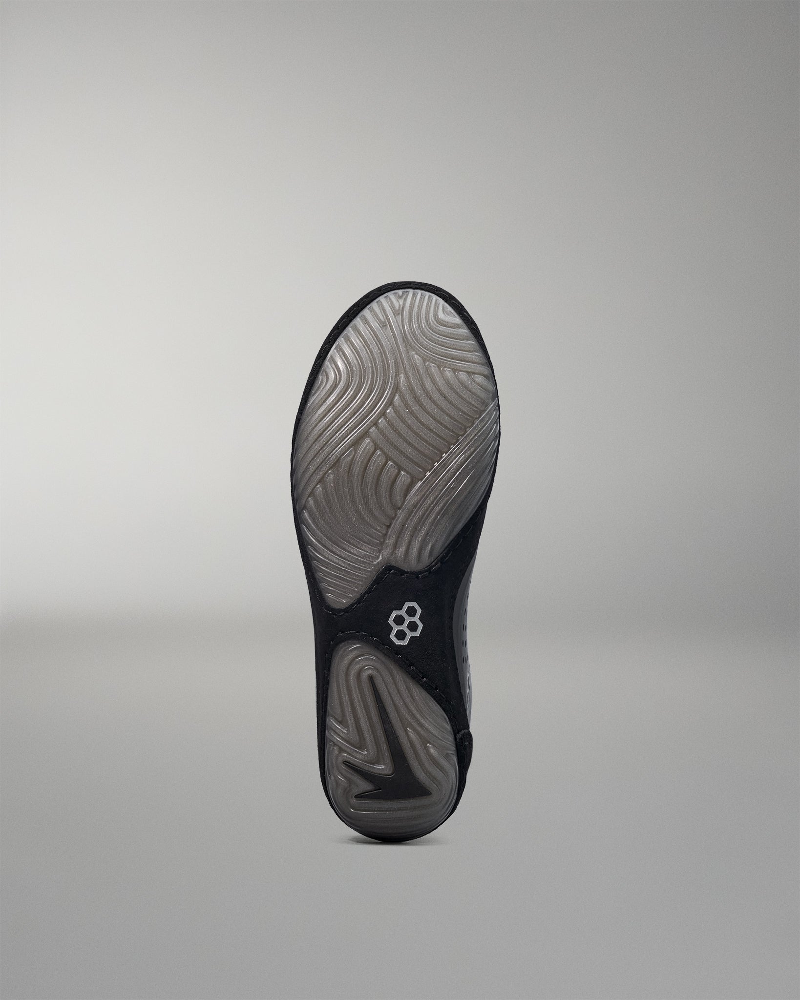 Black wrestling shoe sole with a brand logo on a gray background
