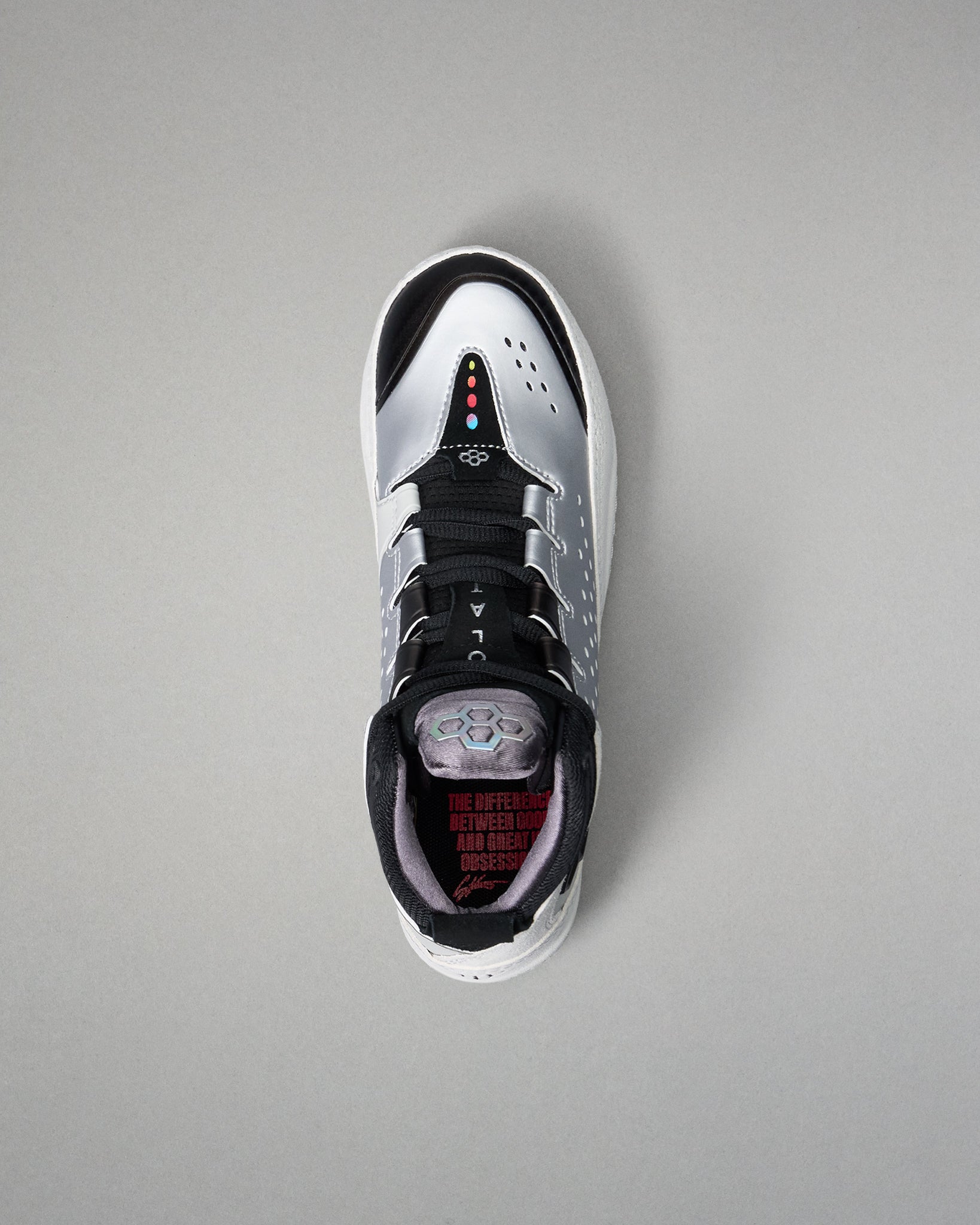 Black and white wrestling shoe with red accents on a gray background