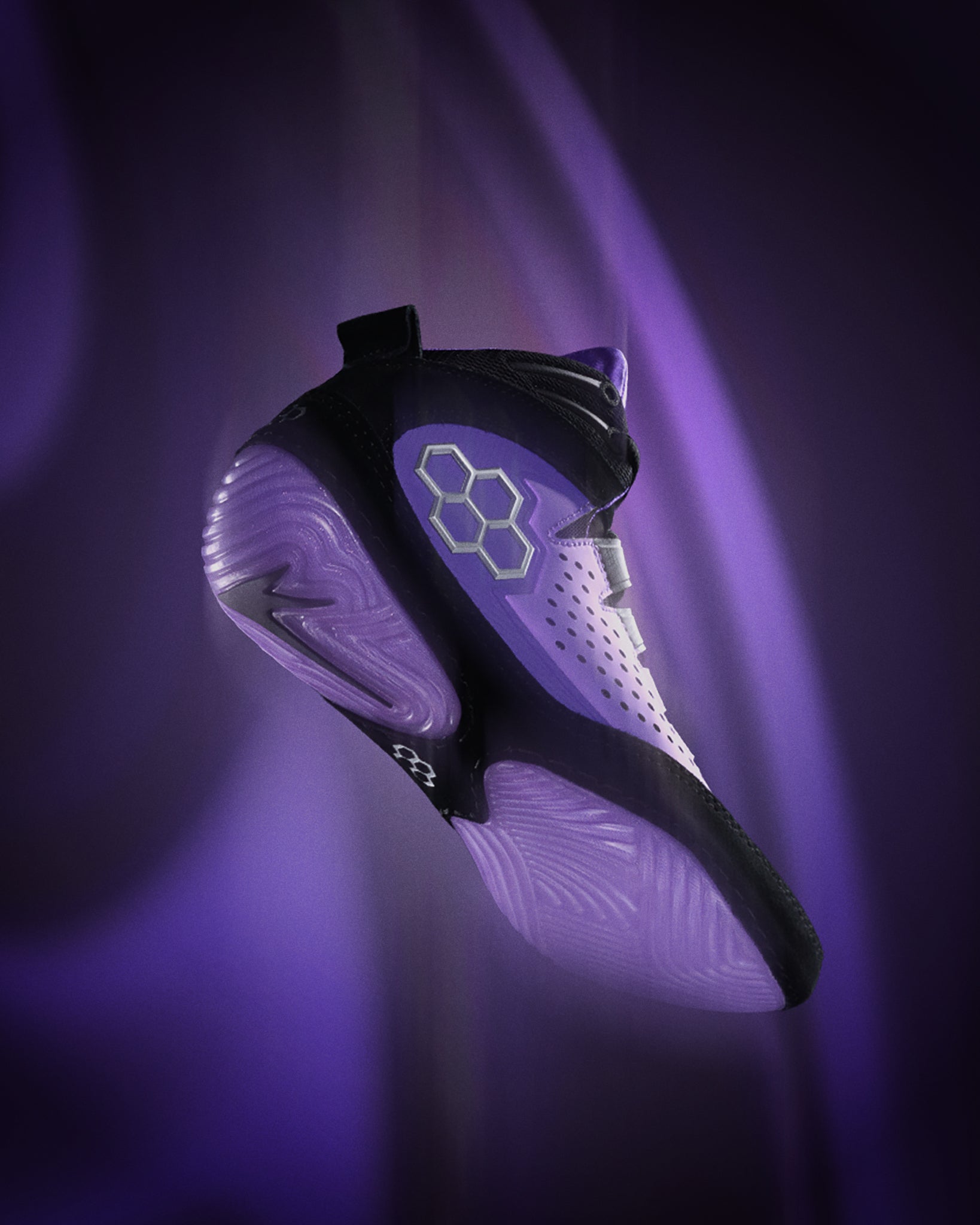 Black and white wrestling shoe with a glowing sole on a dark background