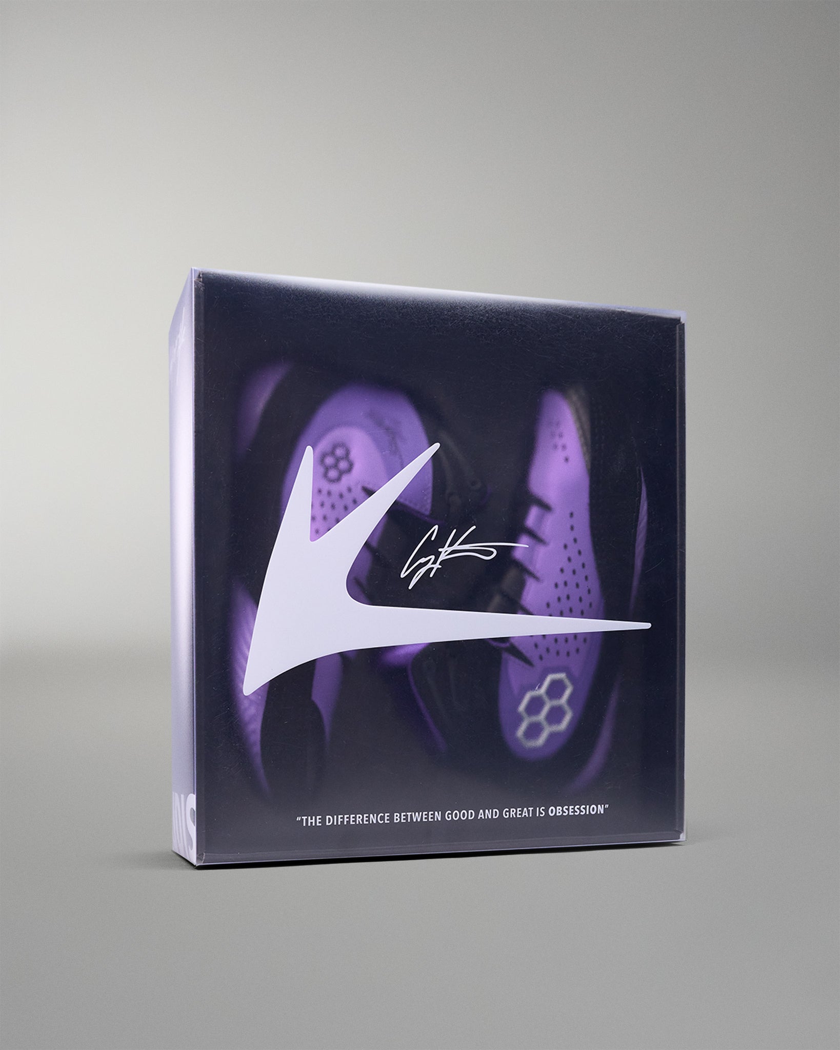 shoe box with purple wrestling shoes and a logo on a gray background