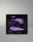 Purple and black wrestling shoes in a black box on a gray background