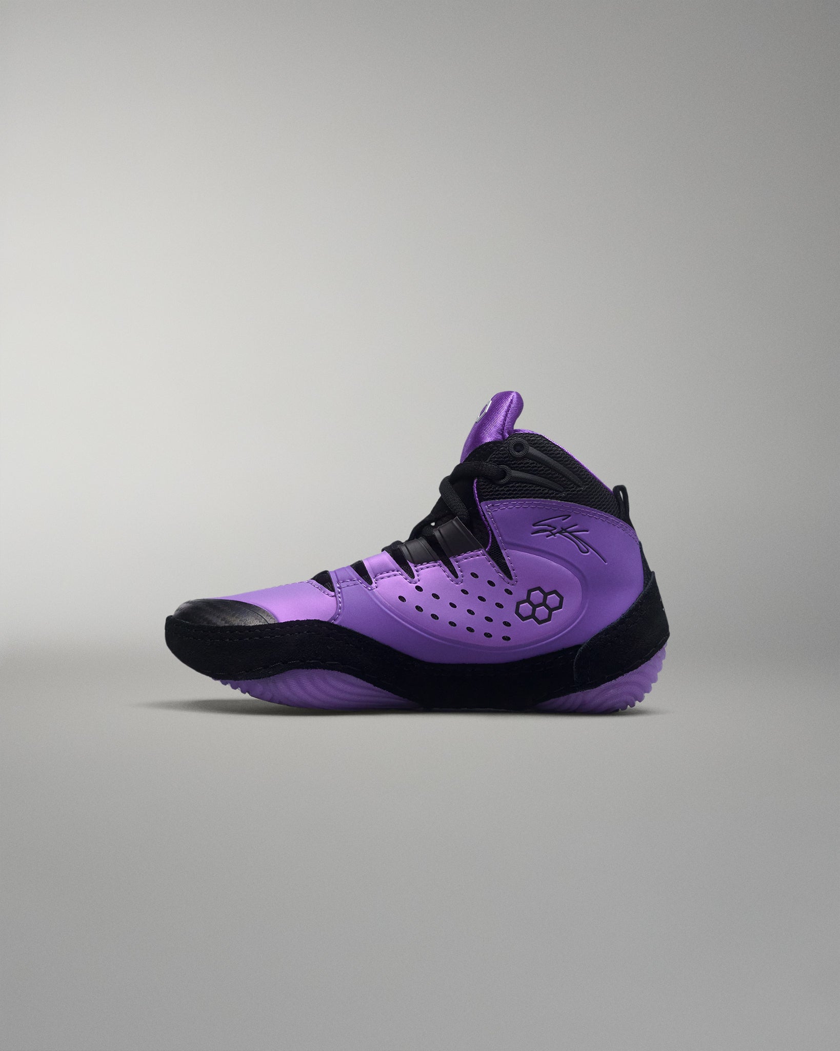 Purple and black wrestling shoe on a gray background