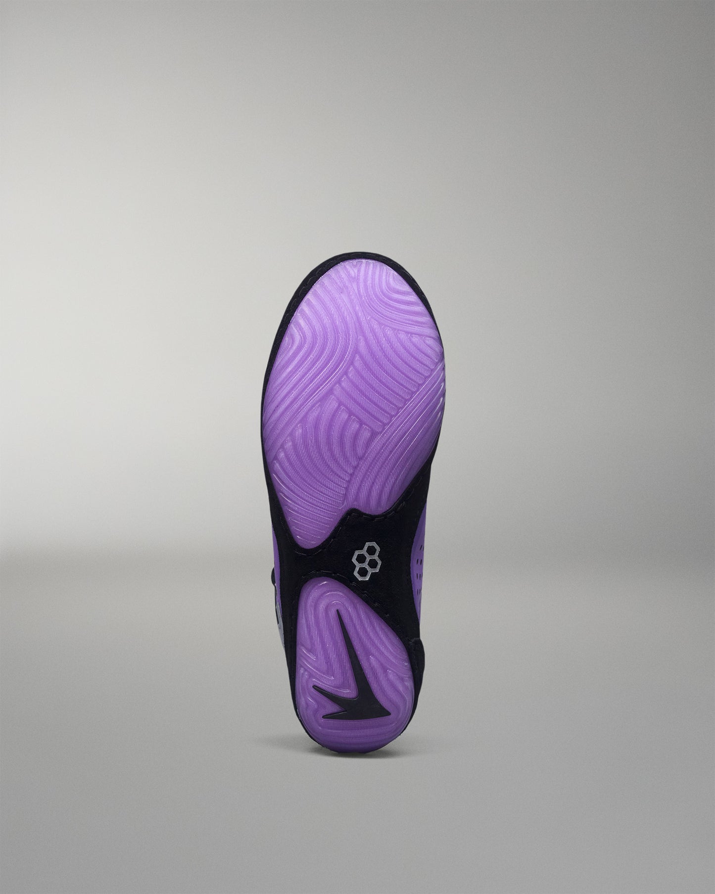 Purple and black wrestling shoe sole on a gray background