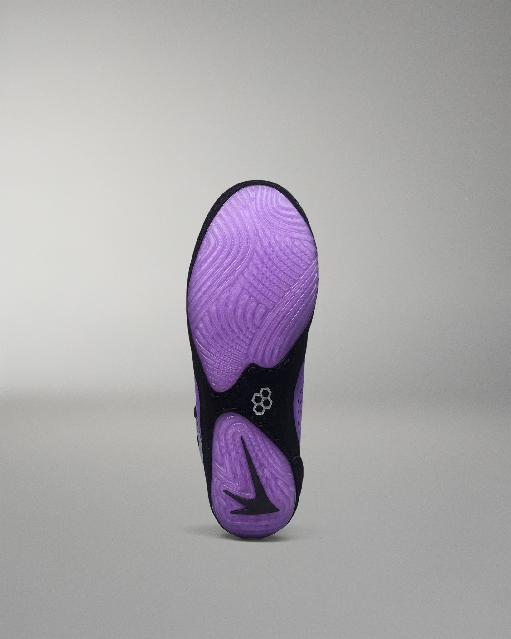 Purple and black wrestling shoe sole on a gray background