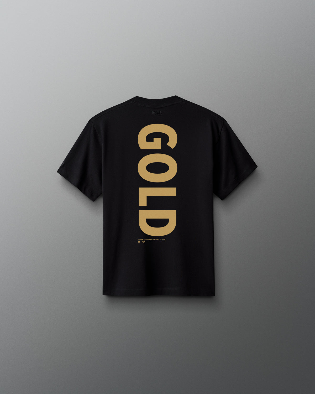 Back view of the black RUDIS Youth JB Gold Heavyweight T-Shirt featuring oversized vertical gold “GOLD” lettering with Jordan Burroughs and RUDIS details beneath the graphic.