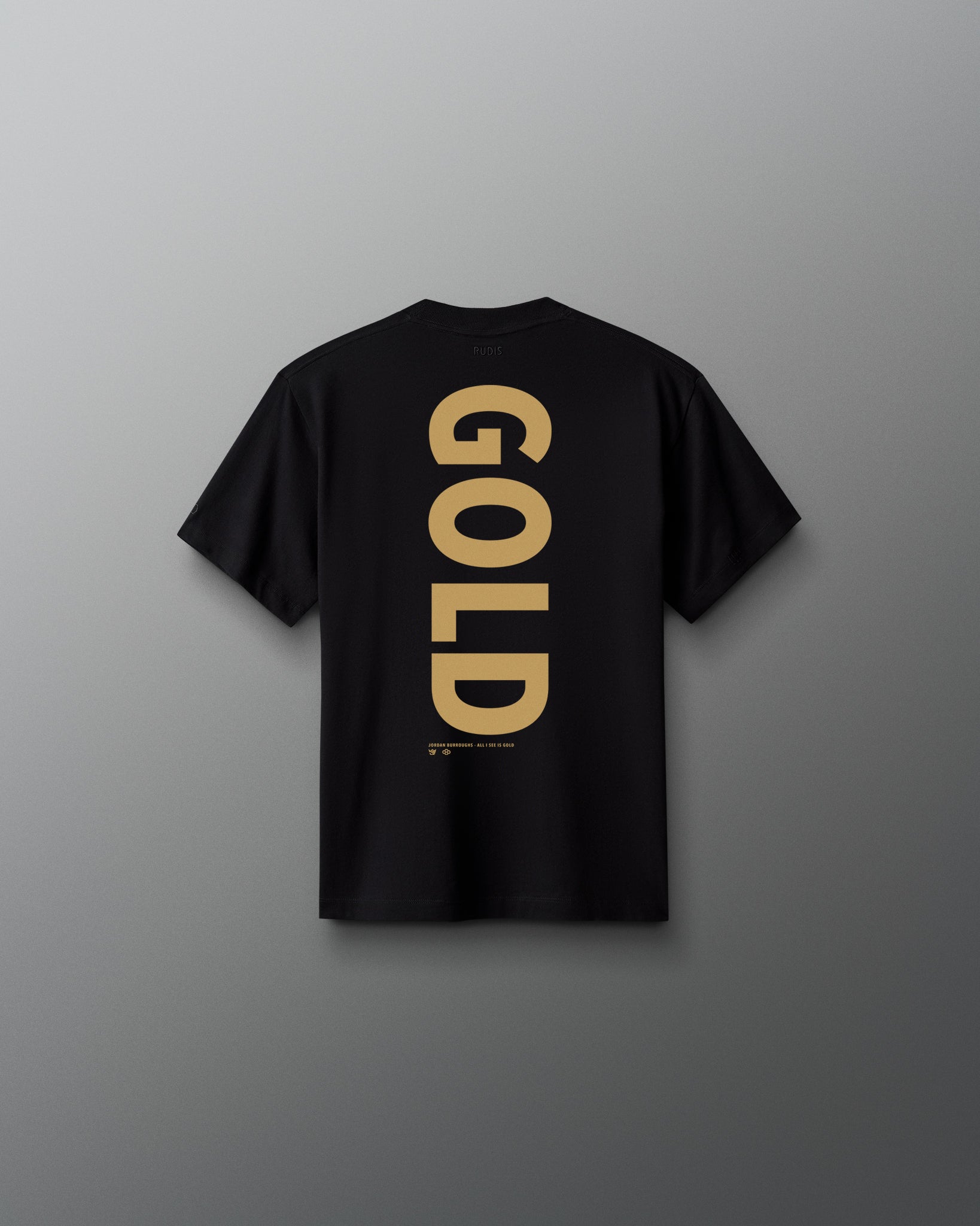 Back view of the black RUDIS Youth JB Gold Heavyweight T-Shirt featuring oversized vertical gold “GOLD” lettering with Jordan Burroughs and RUDIS details beneath the graphic.