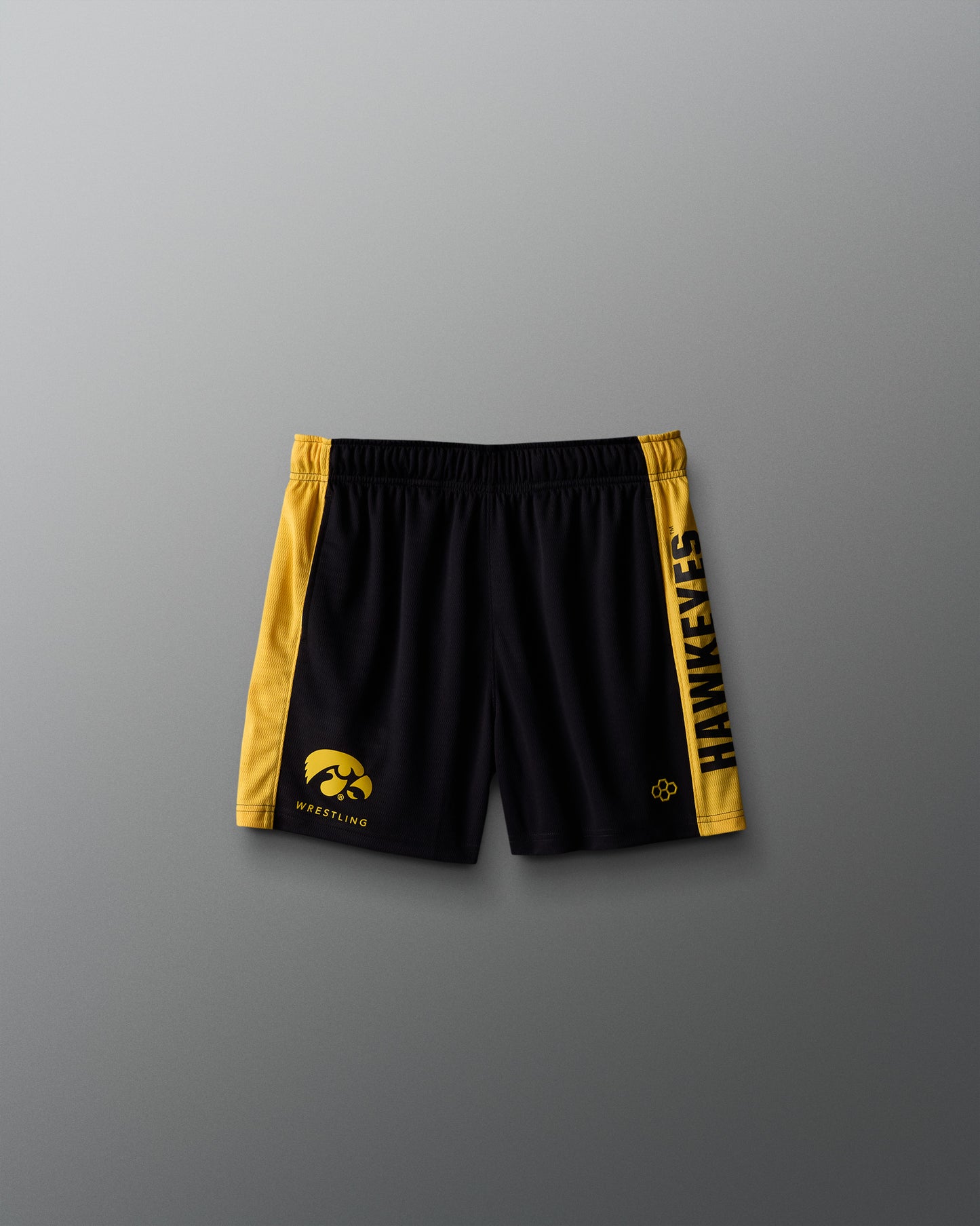 Black shorts with yellow accents and logos on a gray background