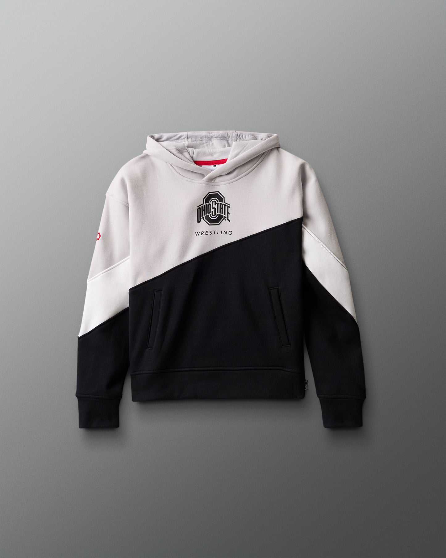 Two-tone black and white hoodie with a logo on a gray background