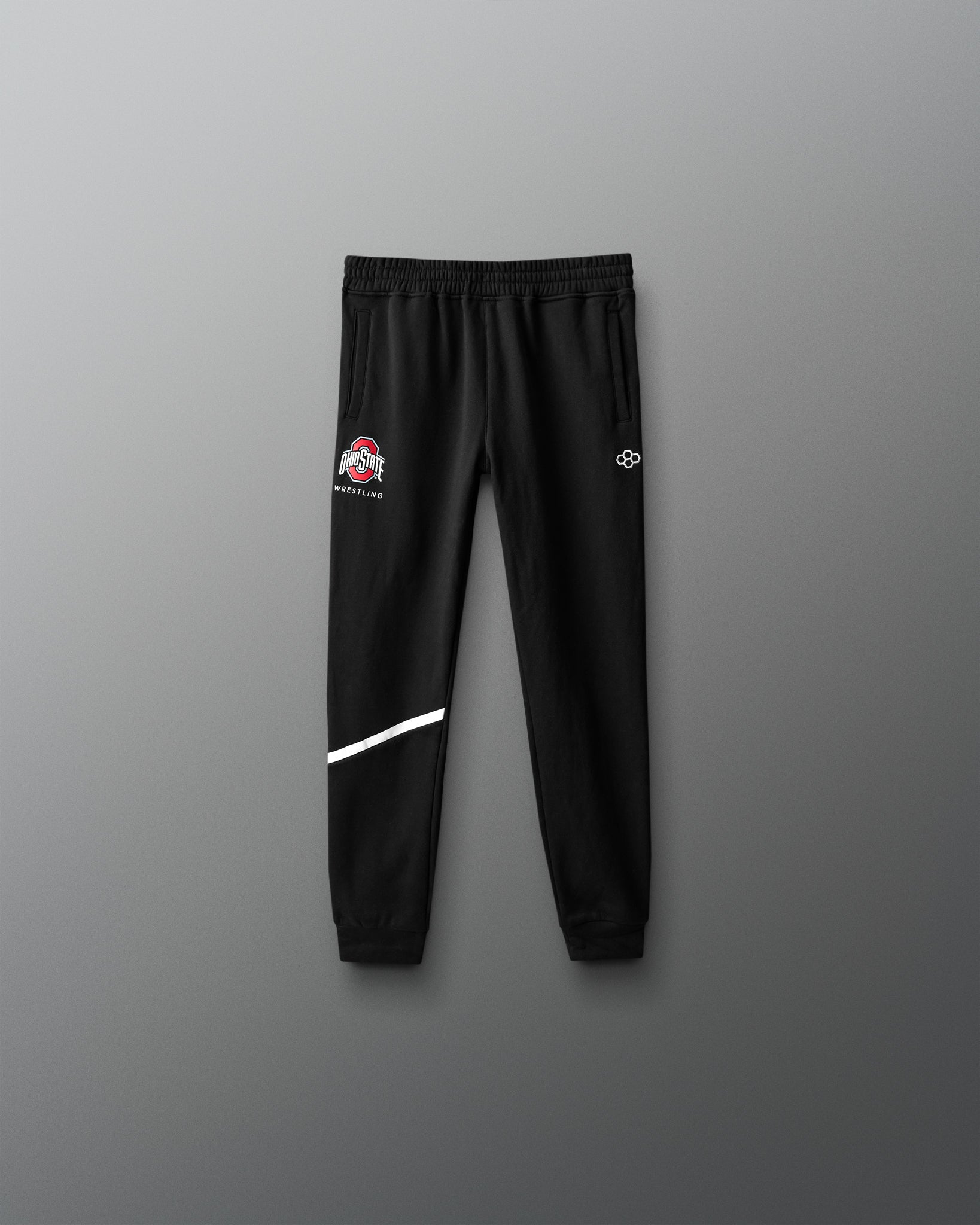 Black sweatpants with logos on a gray background