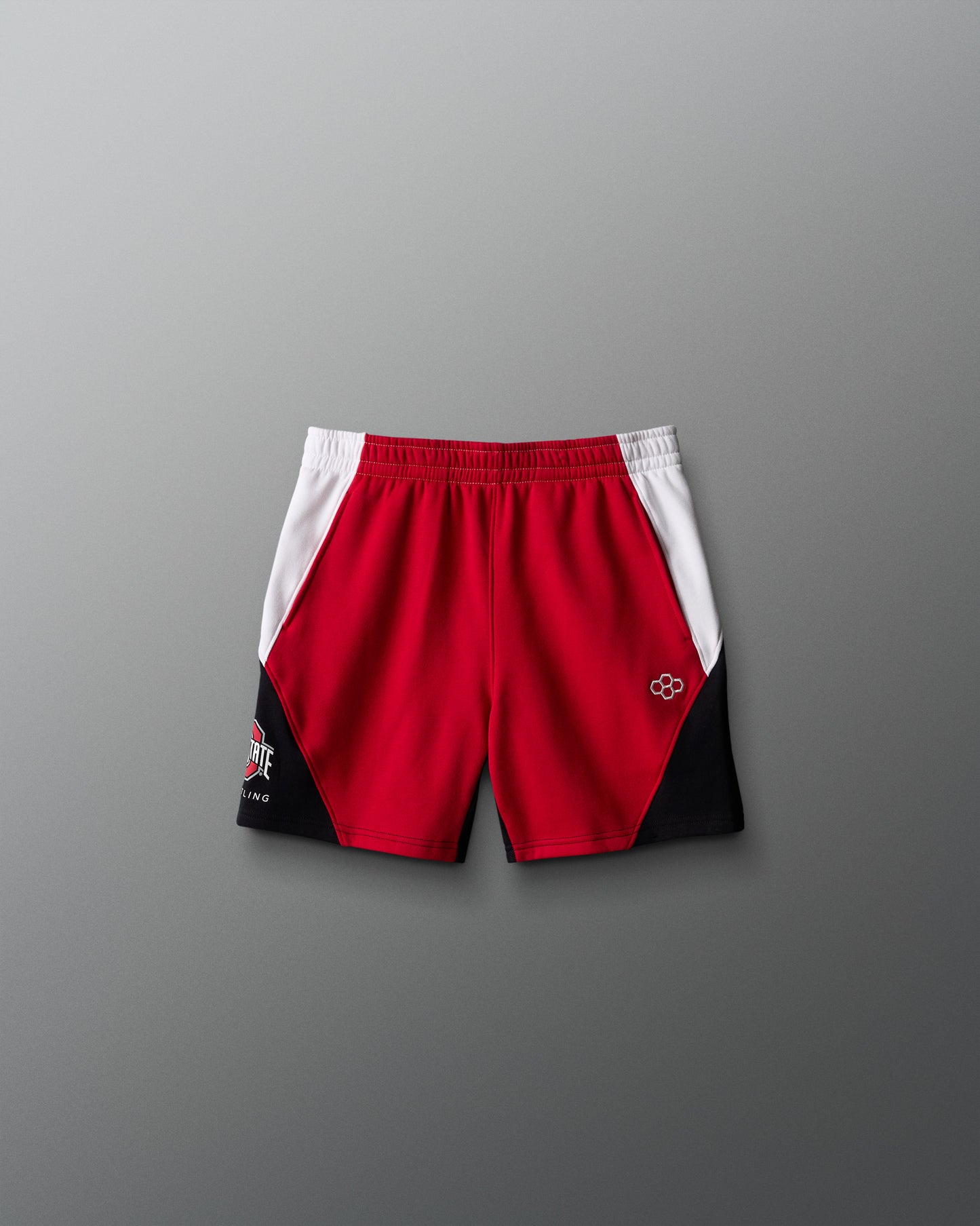 Red and black athletic shorts with a logo on a gray background